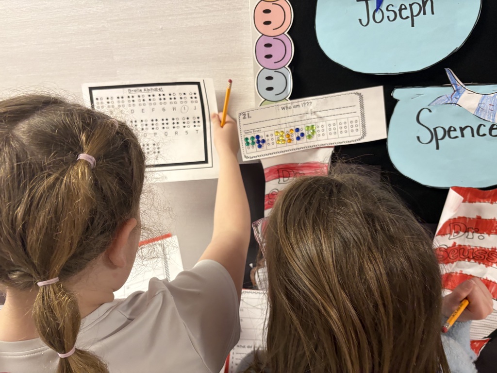 Students exploring braille in a school hallway