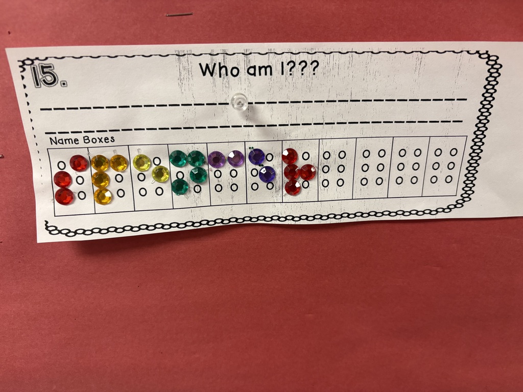 Paper with who am i and rainbow colored gems