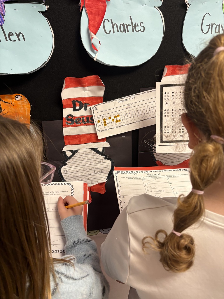 Students exploring braille in a school hallway