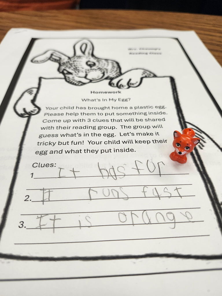 A plastic egg with student writing of three clues of what is inside. 