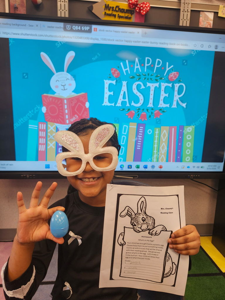 A student holding a plastic easter egg wearing bunny glasses. 