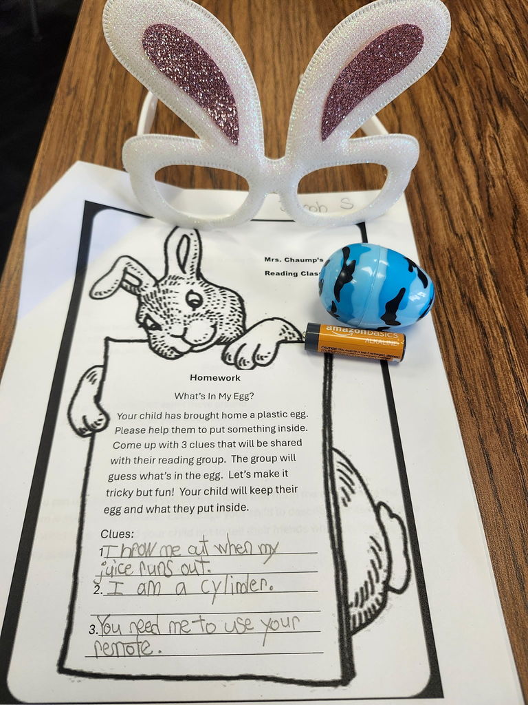 A plastic egg with student writing of three clues of what is inside. 
