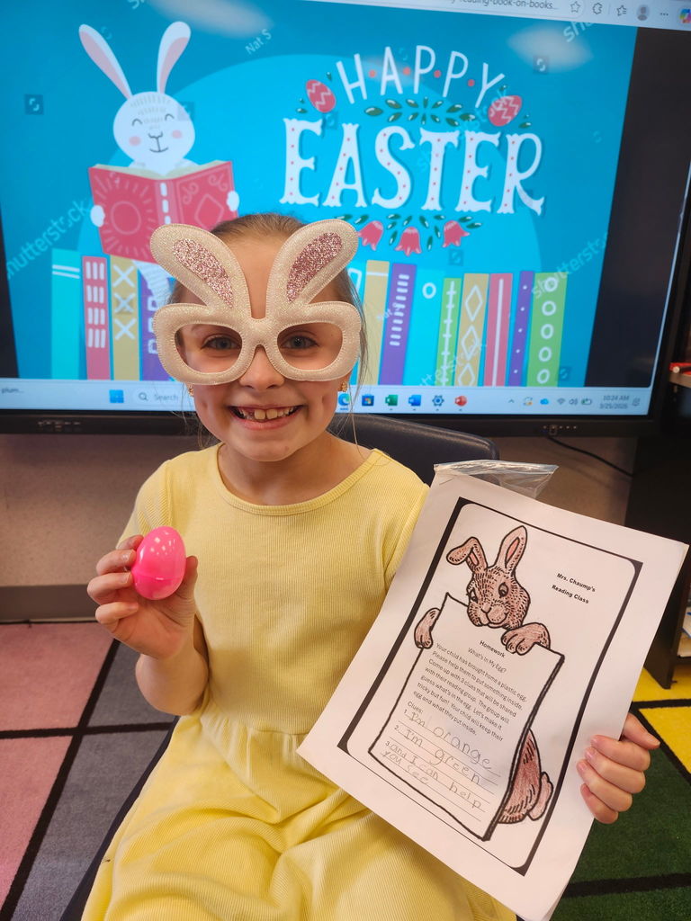 A student holding a plastic easter egg wearing bunny glasses. 