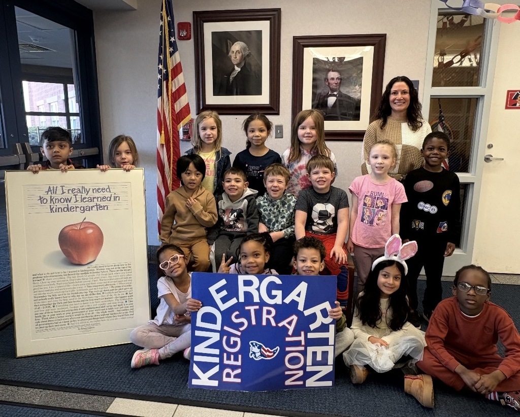 A group of students holding a sign that says kindergarten registration