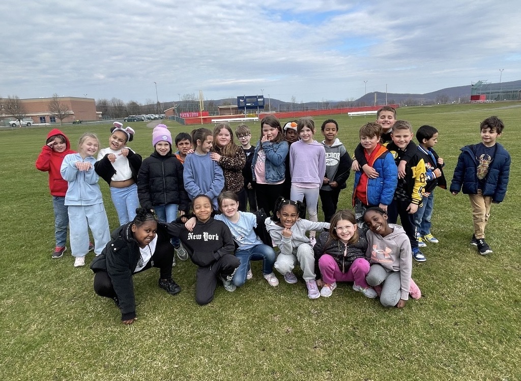 A group of students in a field outside of the school.  