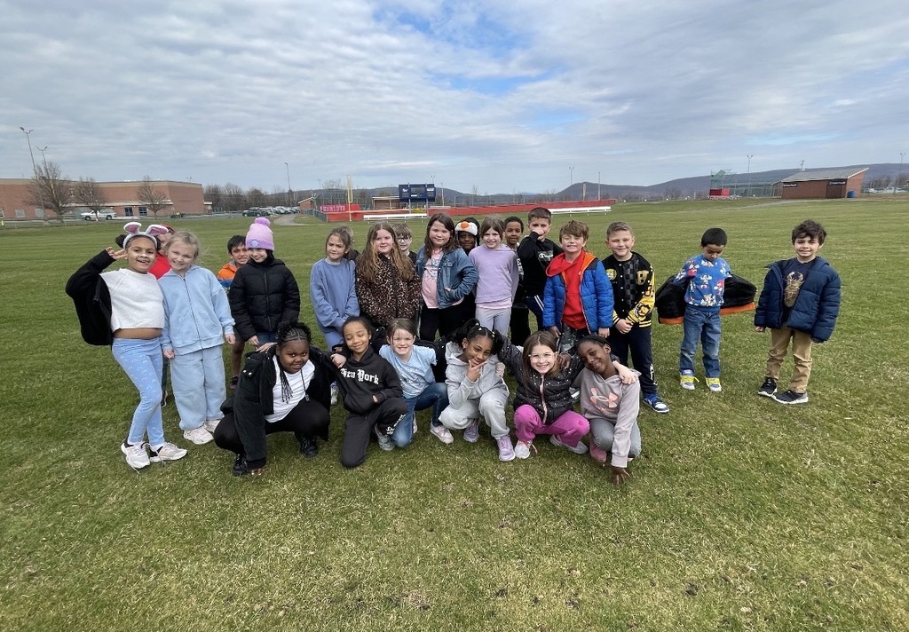 A group of students in a field outside of the school.  