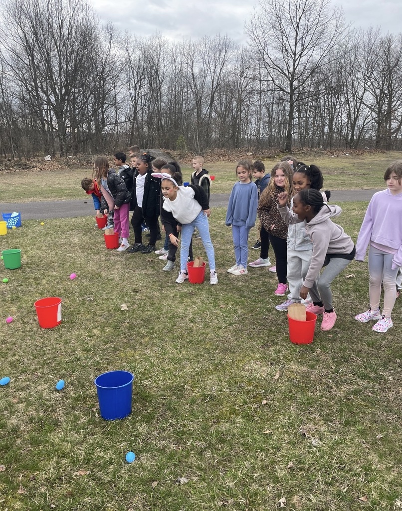 A group of students in a field outside of the school.  