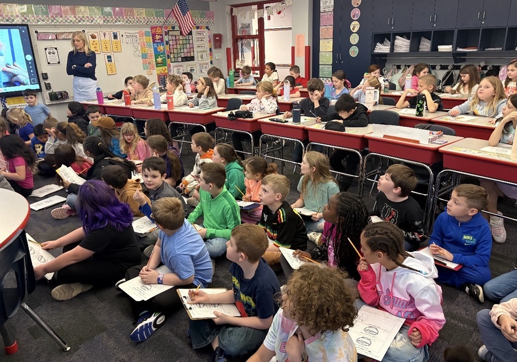 Students seated with clipboards observing blue marshmallow peeps in different liquids  