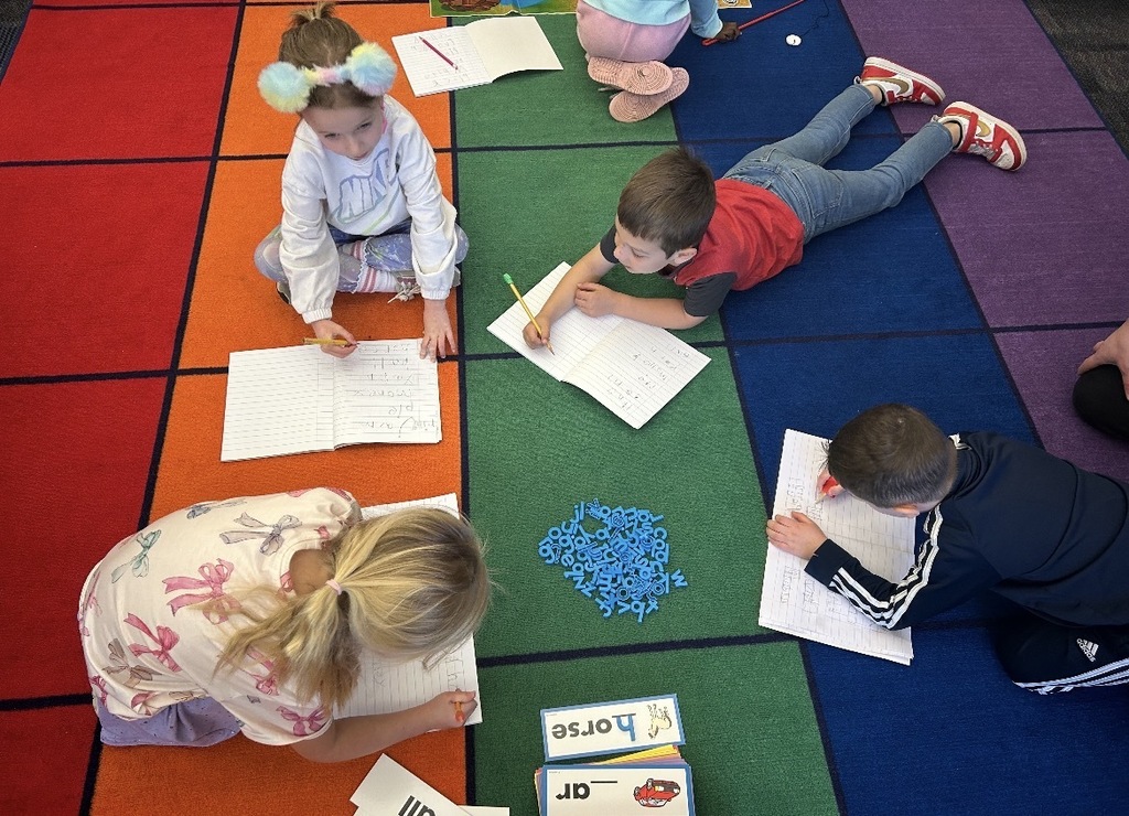 Students working with literacy materials in a kindergarten classroom. 