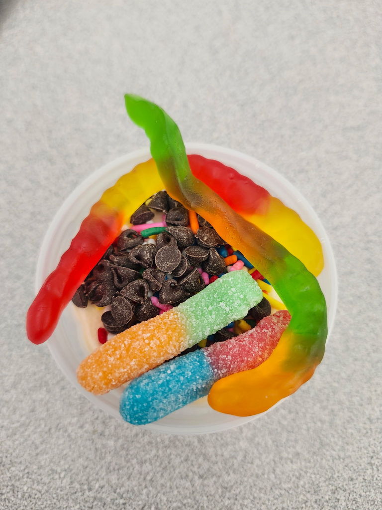 An ice cream cup with candy toppings