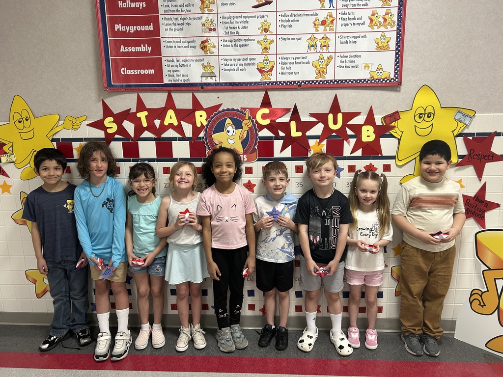 Students smiling with stars in front of the start club board