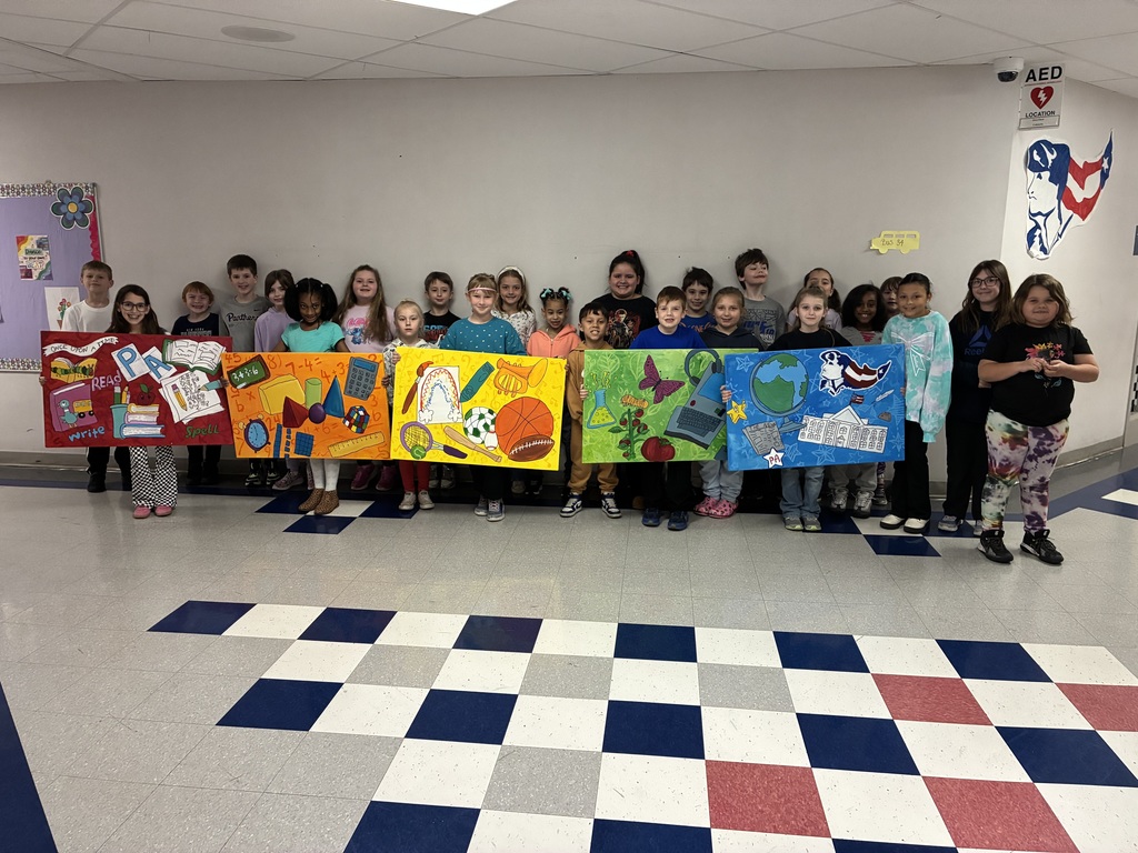 A group of students holding a canvas with school themed items