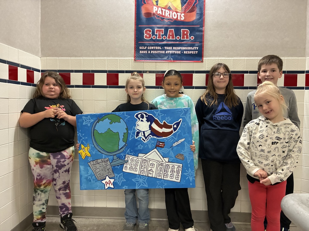 A group of students holding a canvas with school themed items