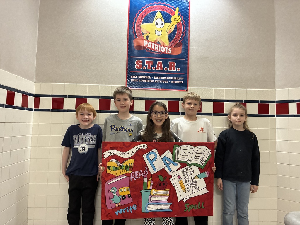 A group of students holding a canvas with school themed items