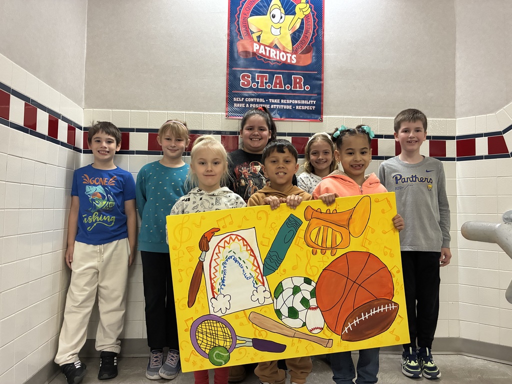 A group of students holding a canvas with school themed items