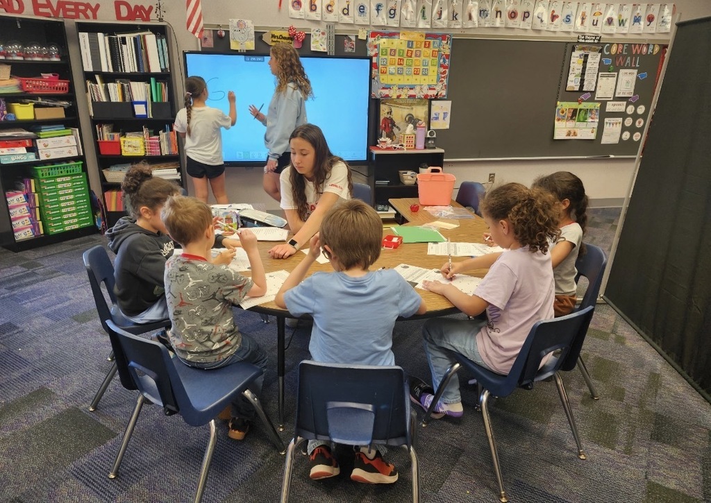 A  child working as a teacher on bring your kid to work day. 
