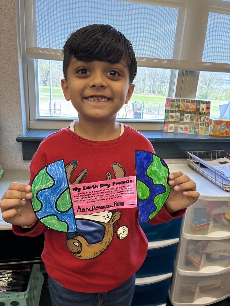 A boy holding an earth day craft with an earth day poem.