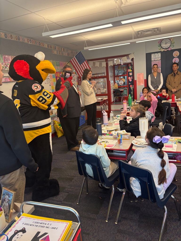 Students with penguin hockey representatives and tux mascot  