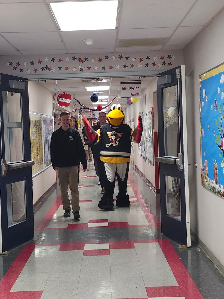 Students with penguin hockey representatives and tux mascot  