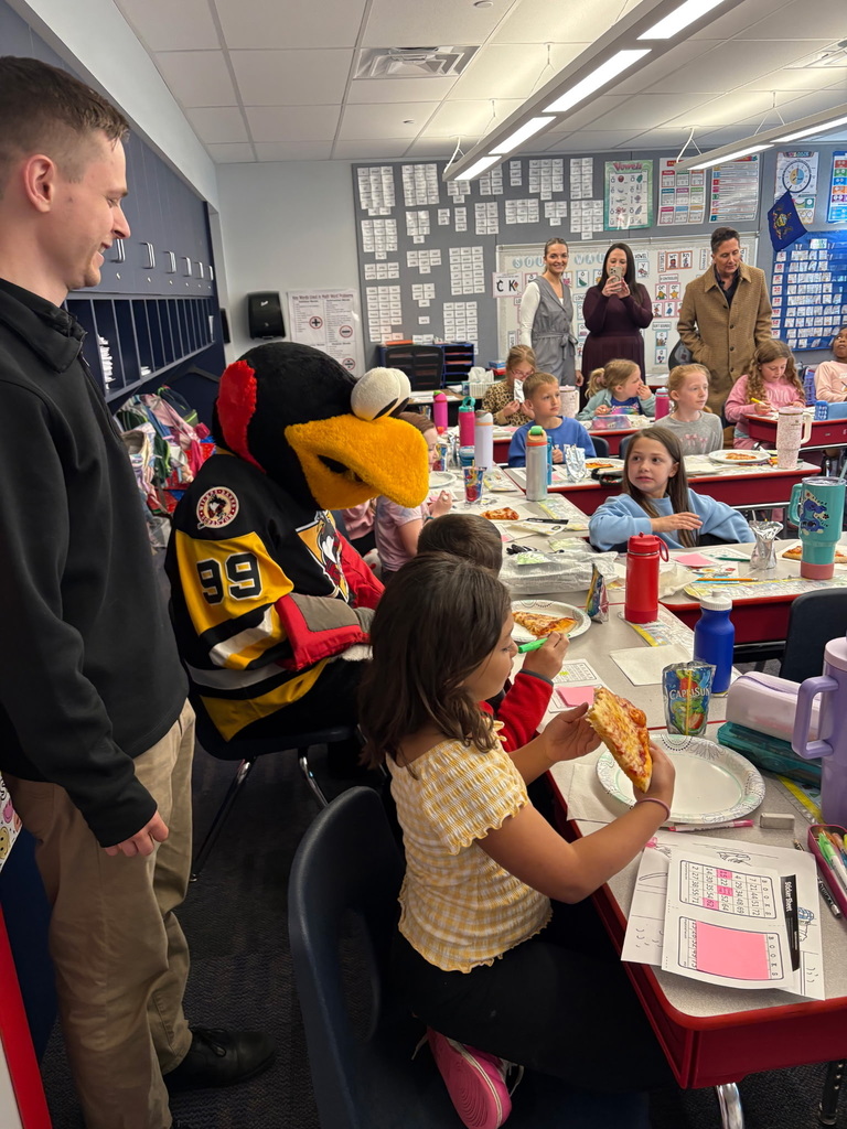 Students with penguin hockey representatives and tux mascot  