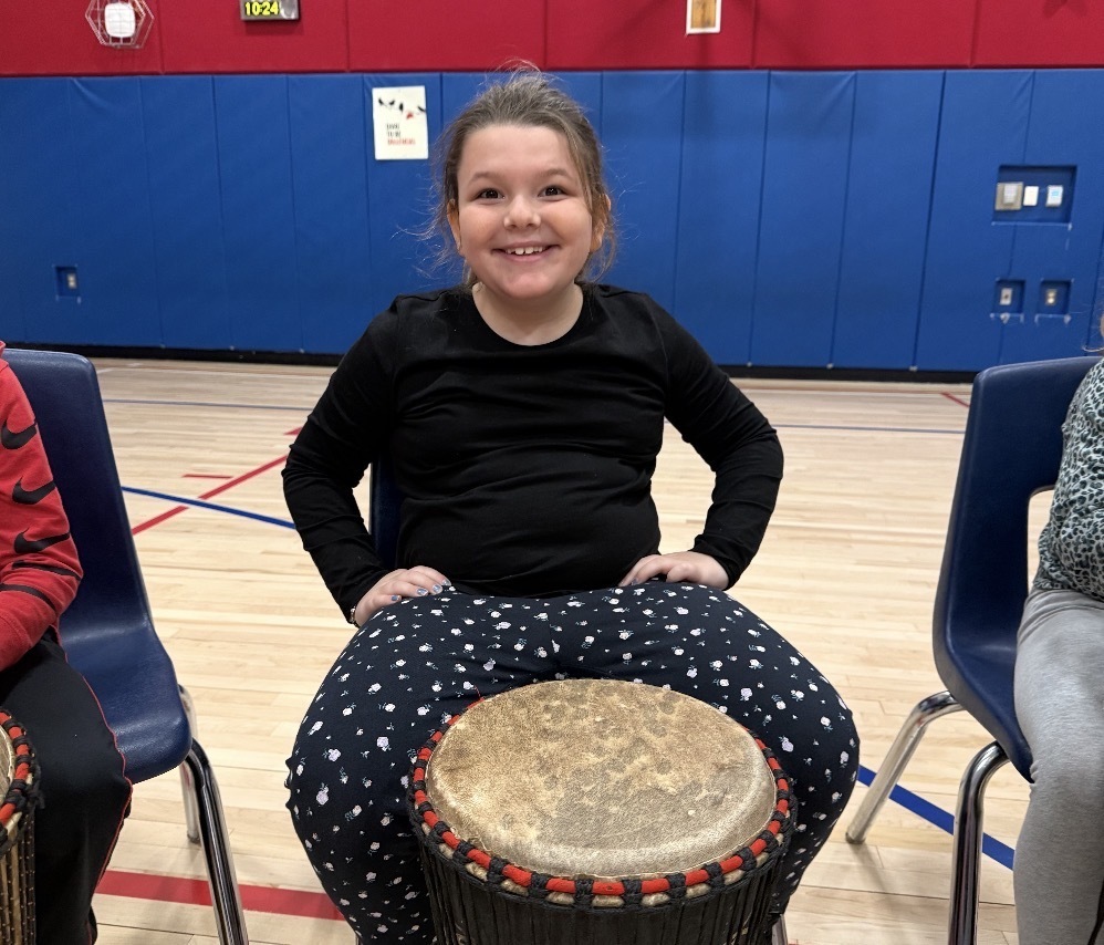 African drummer with students in a gym with drums. 