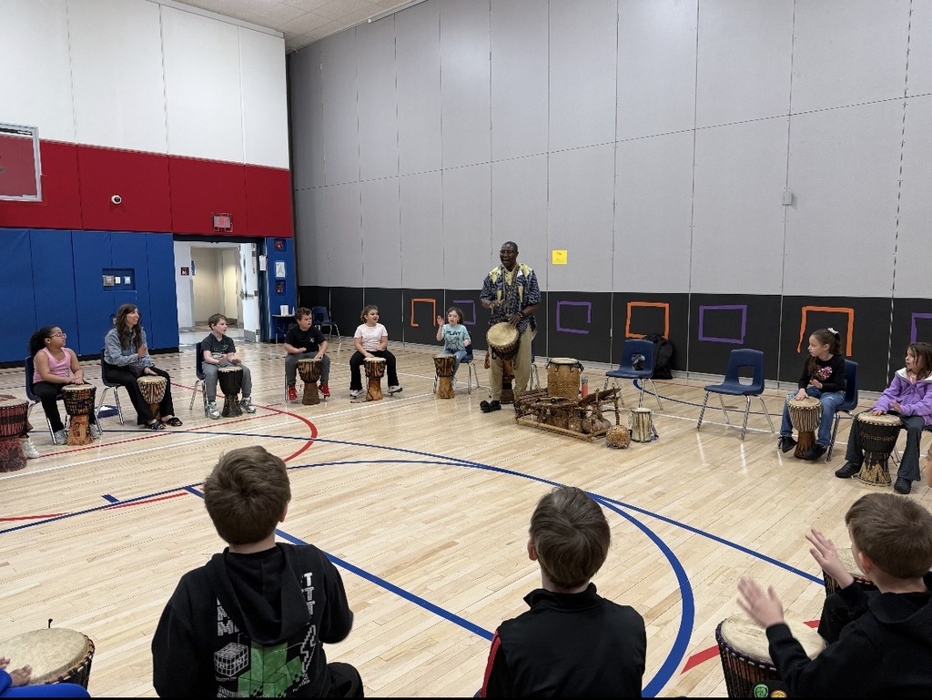 African drummer with students in a gym with drums. 