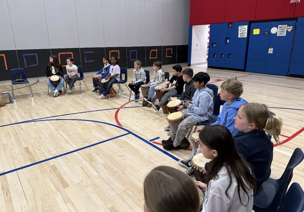 African drummer with students in a gym with drums. 
