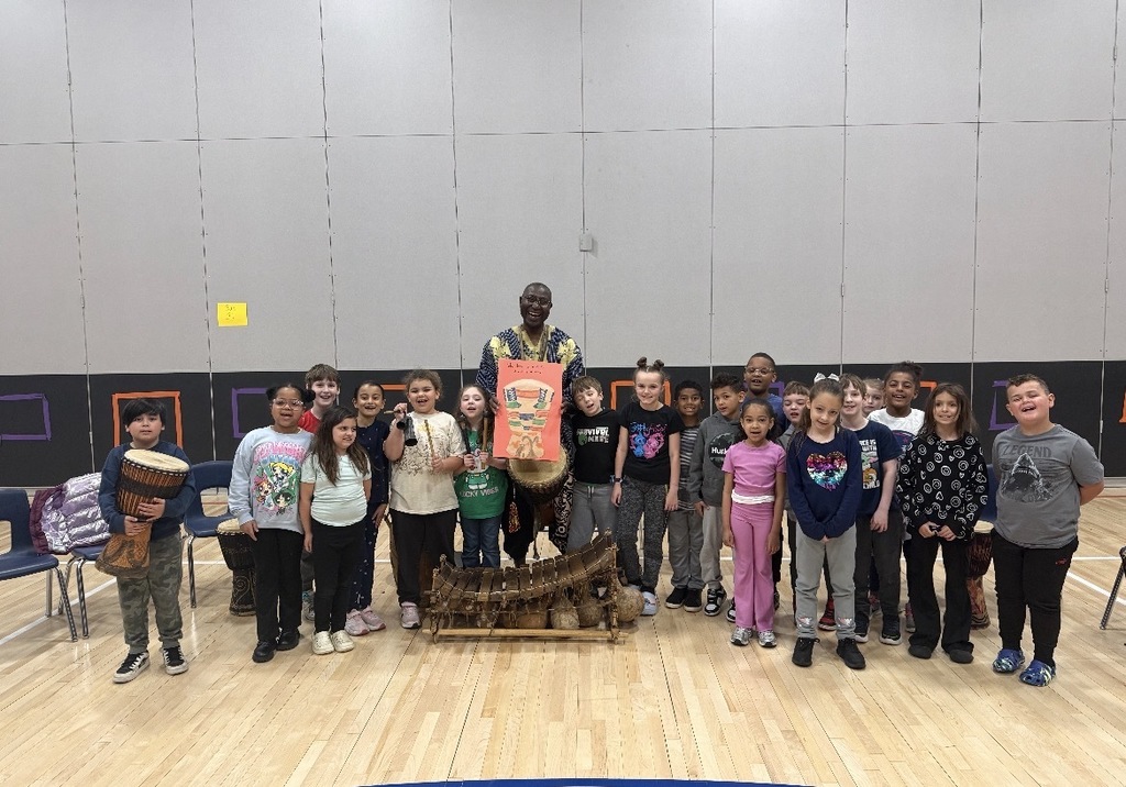 African drummer with students in a gym with drums. 