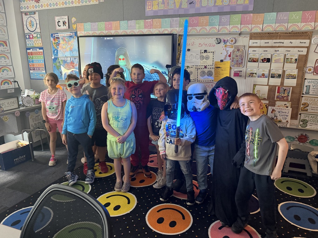 A class posing for a picture celebrating star wars day. 
