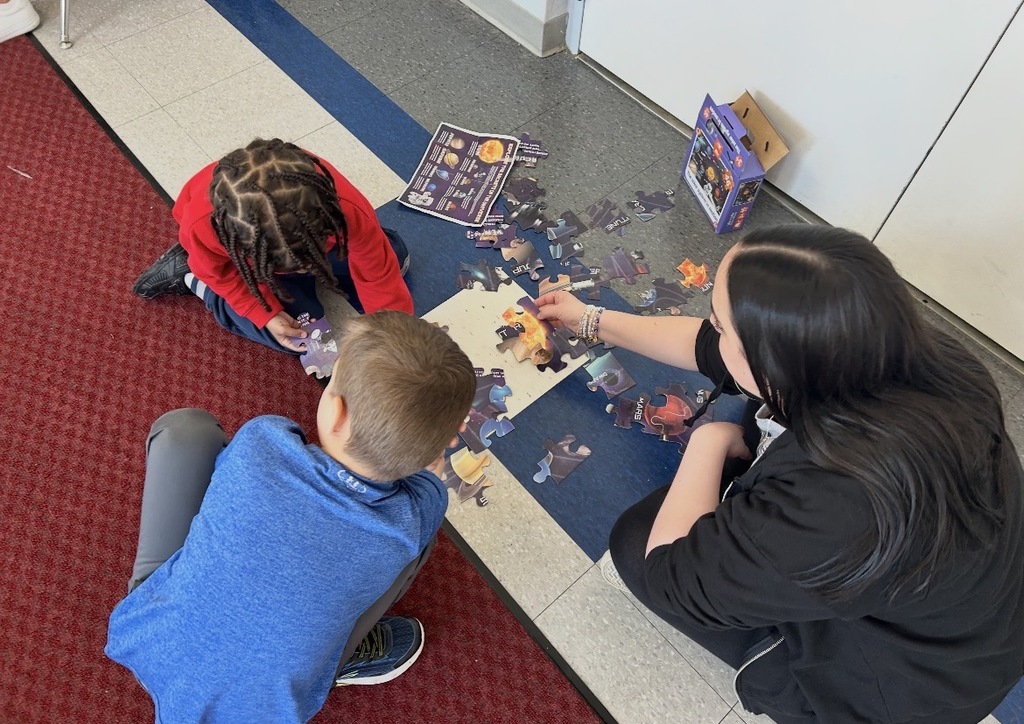 Students working on a solar system puzzle. 