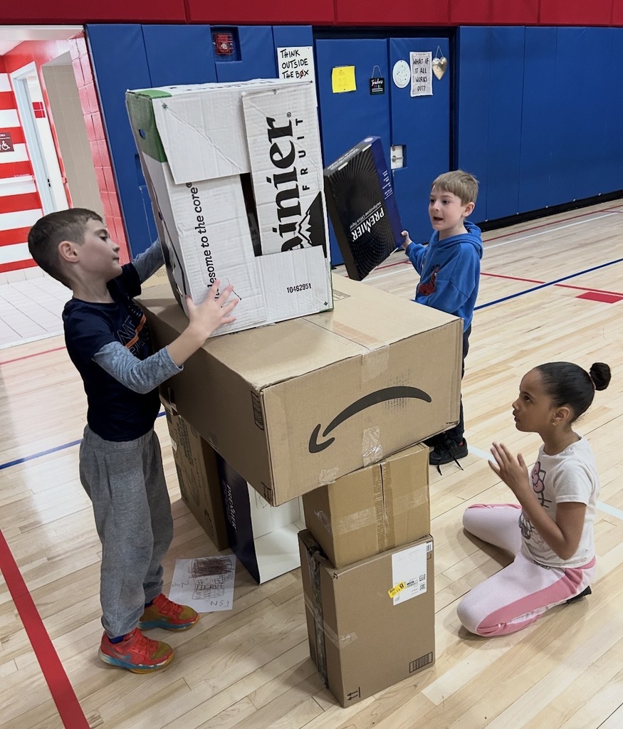 Students building a solar shelter out of boxes. 