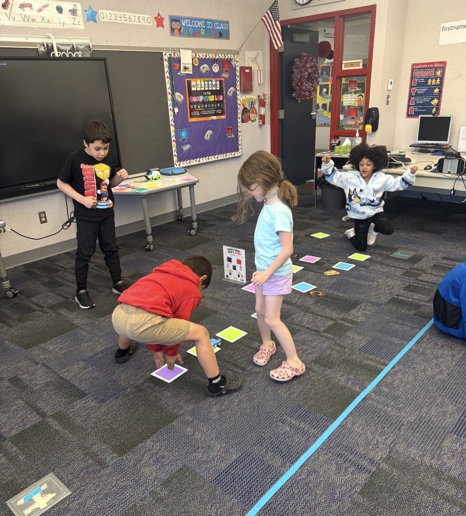 Studens playing with coding cars and color squares 
