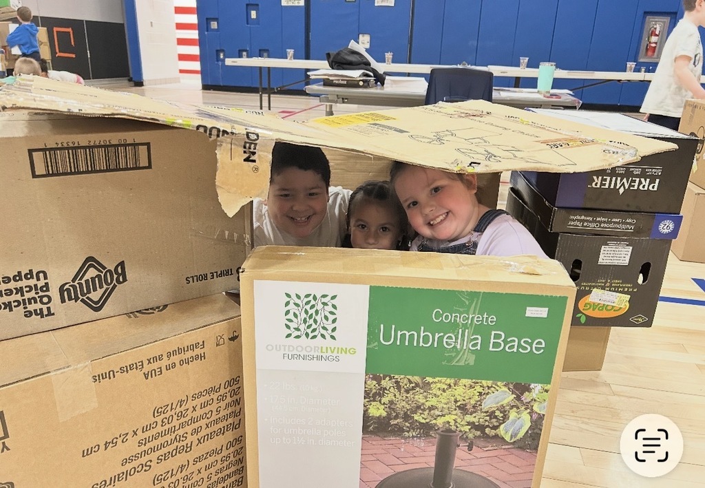Students building a solar shelter out of boxes. 