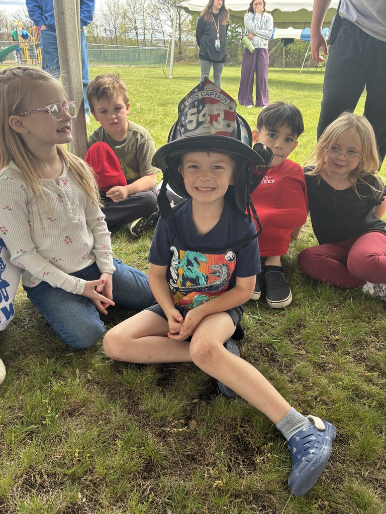 A student wearing a fire helmet. 