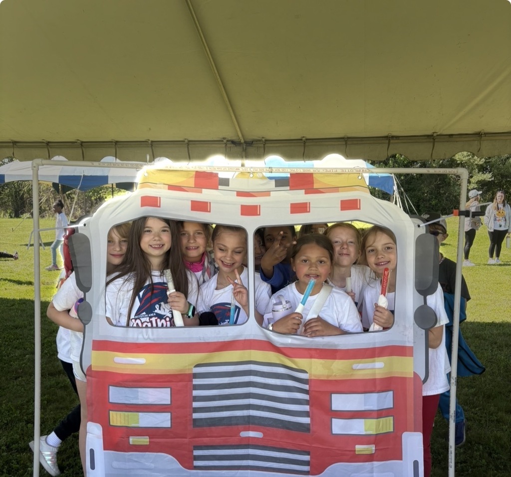 Students at field day in a fire truck photo prop. 