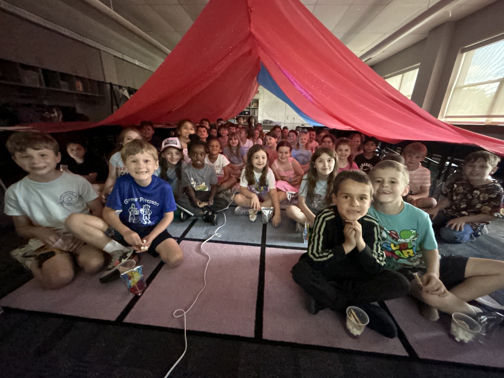 Students under a giant red tent in their classroom. 