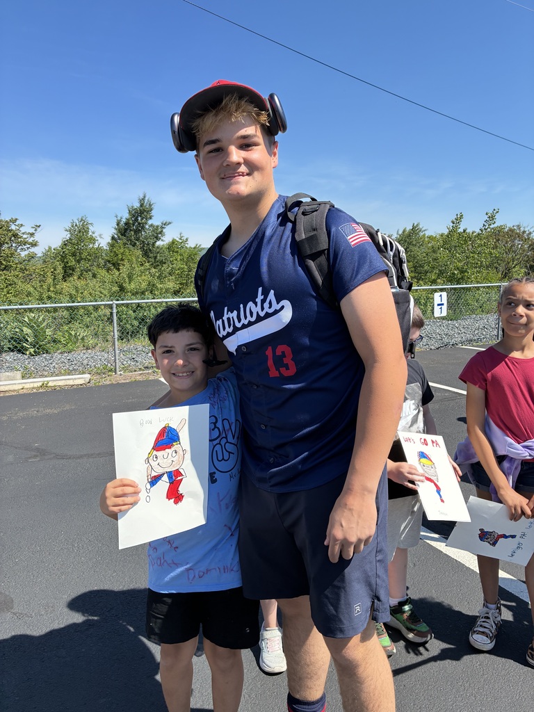 Primary center students outside cheering on the baseball team  