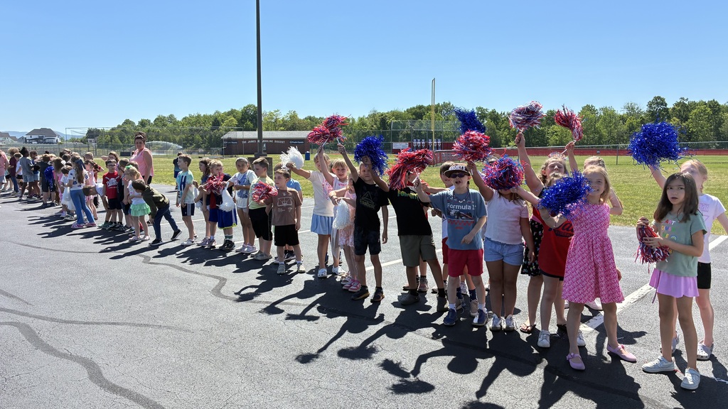 Primary center students outside cheering on the baseball team  
