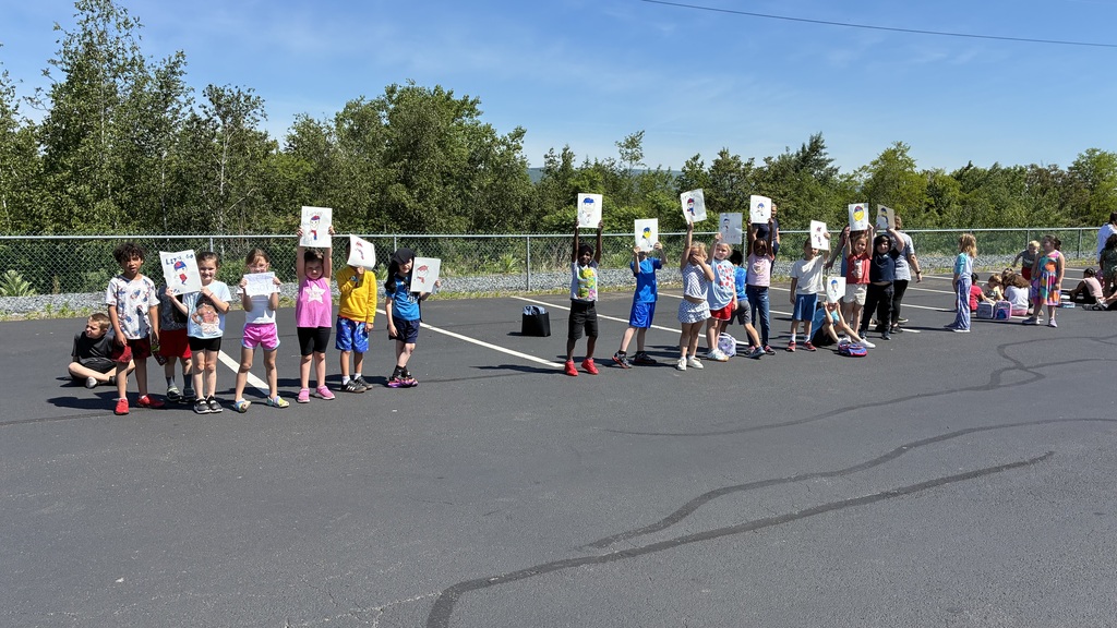 Primary center students outside cheering on the baseball team  