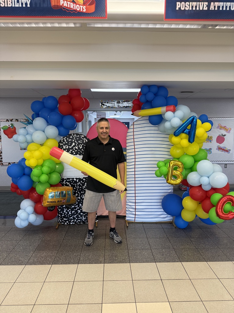 Mr. Savokinas in front of a balloon arch.