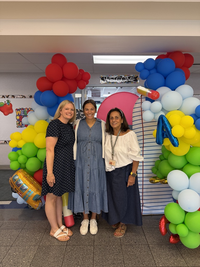 Teachers infront of a ballon backdrop in the school lobby!