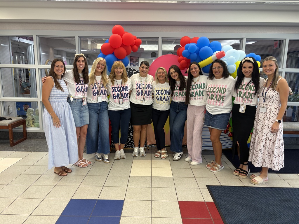 A group of teachers in front of balloons,