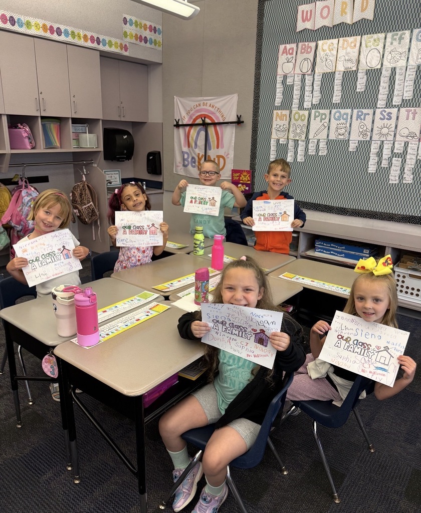 Students holding class family signed posters