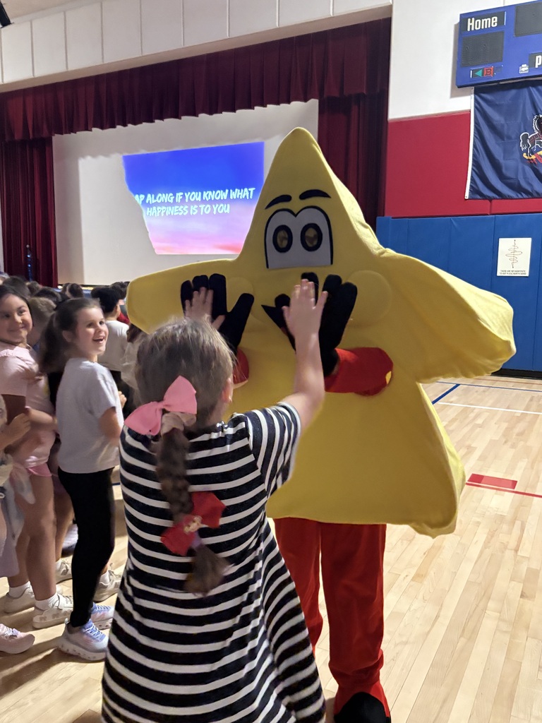 Students in the gym at a star assembly