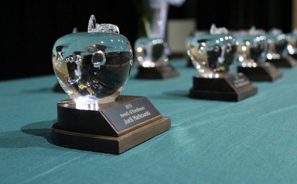 crystal apple awards lined up on table