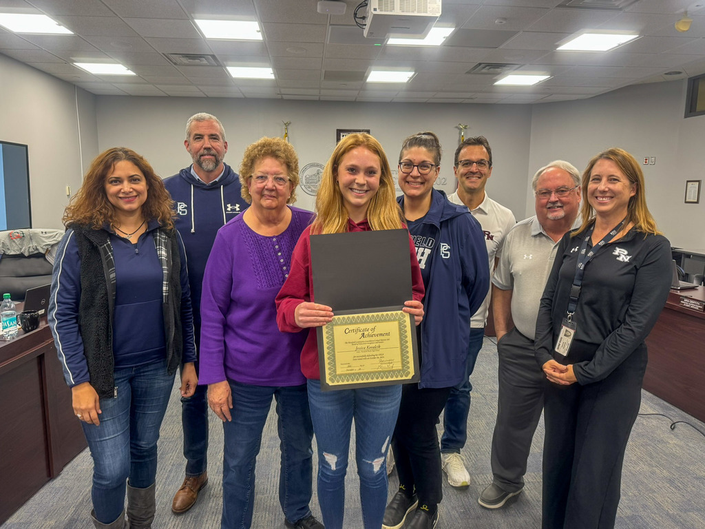 group of people standing, one holds certificate