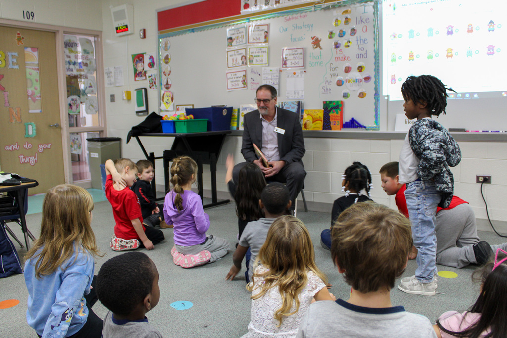 man sits in front of students sitting on floor