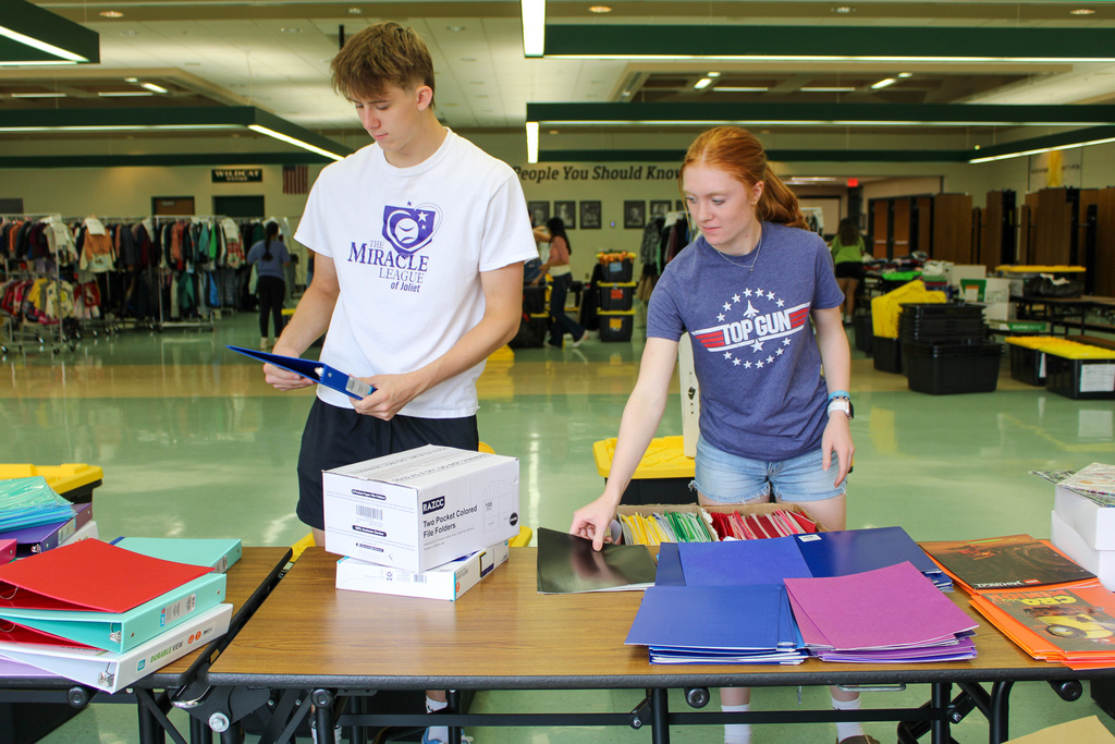 male and female students organize school supplies