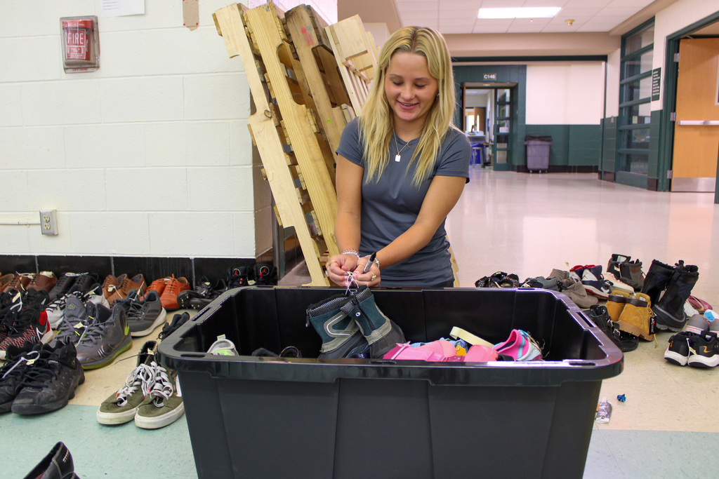 high school studetn organizes shoes in black bucket