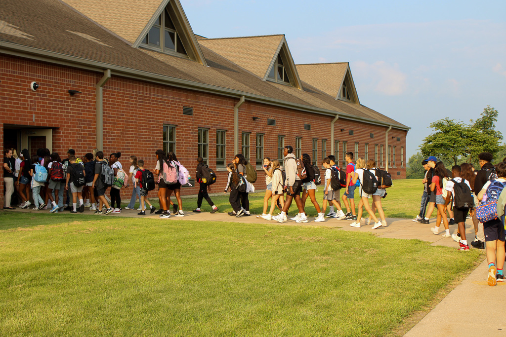 students file into school from buses
